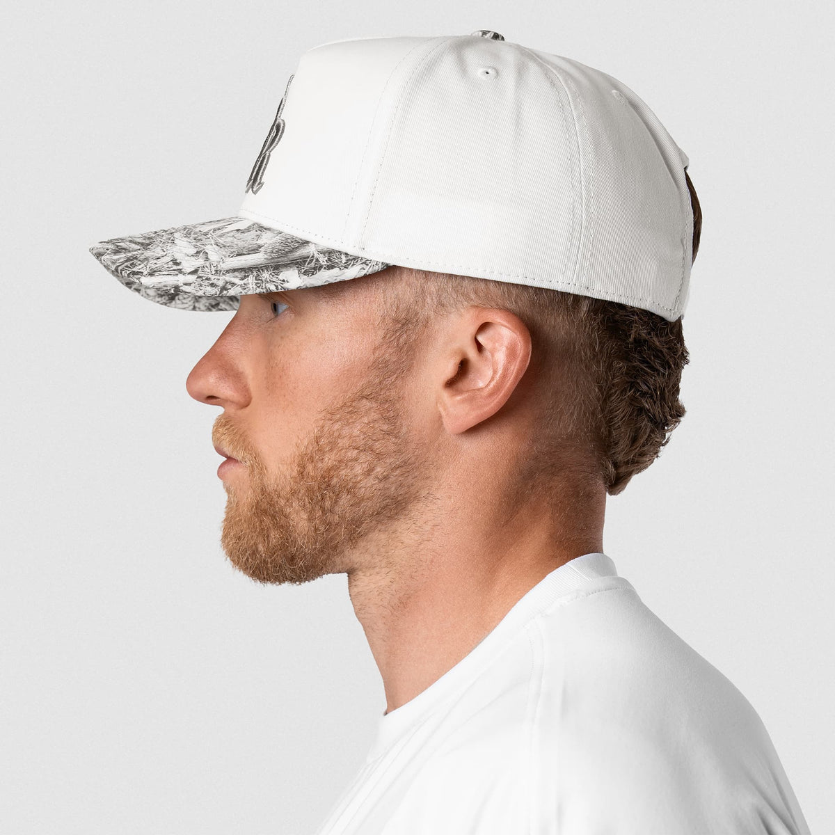 Male model wearing the 5-Panel Initial Hat - White Camo left side view