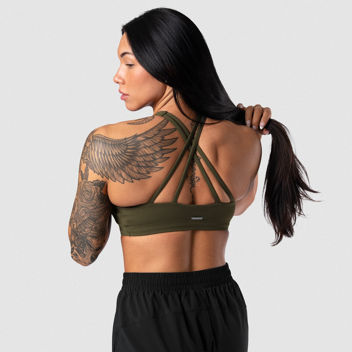 Female model wearing the Axis High Neck Bra - OD Green back view