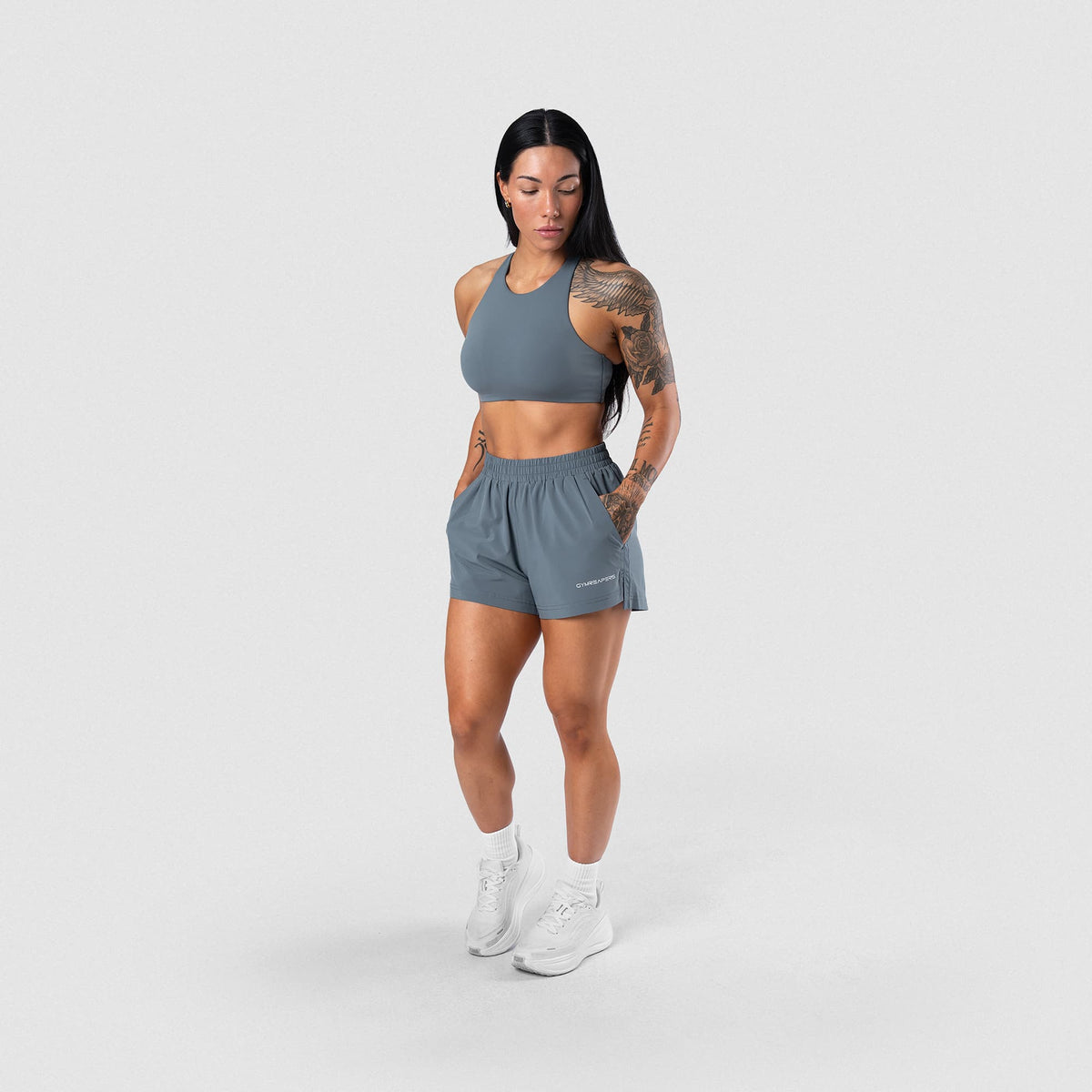 Female model wearing the Axis High Neck Bra - Lake full-body view