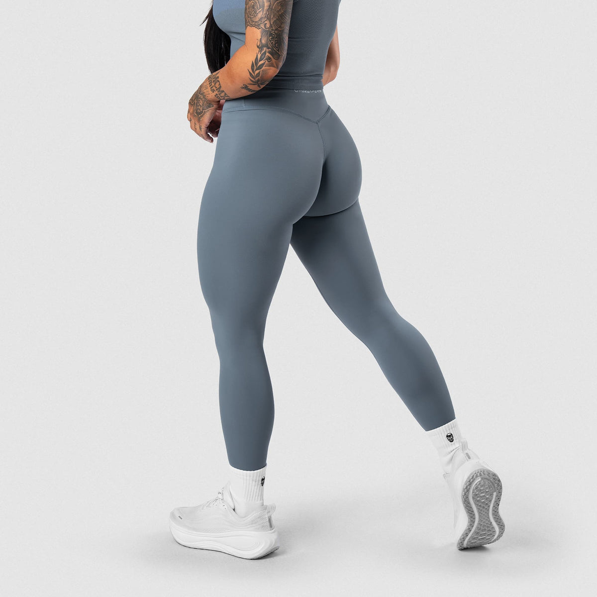 Female model wearing the Axis Leggings - Lake side-back view