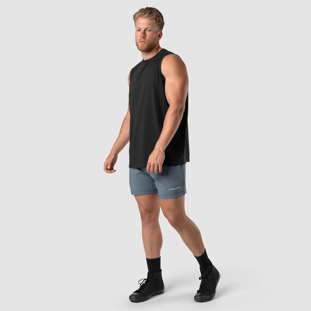 Man wearing Axis Muscle Tank - Black/Black full-body walking view