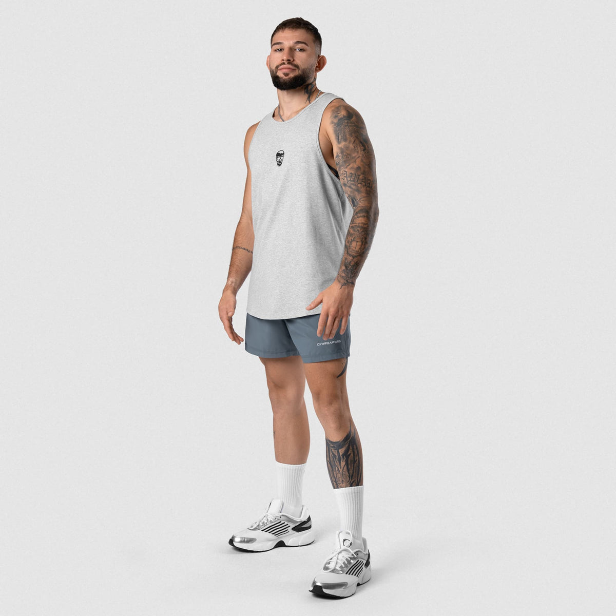 Male model wearing the Axis Scoop Hem Tank - Heather Gray full-body view