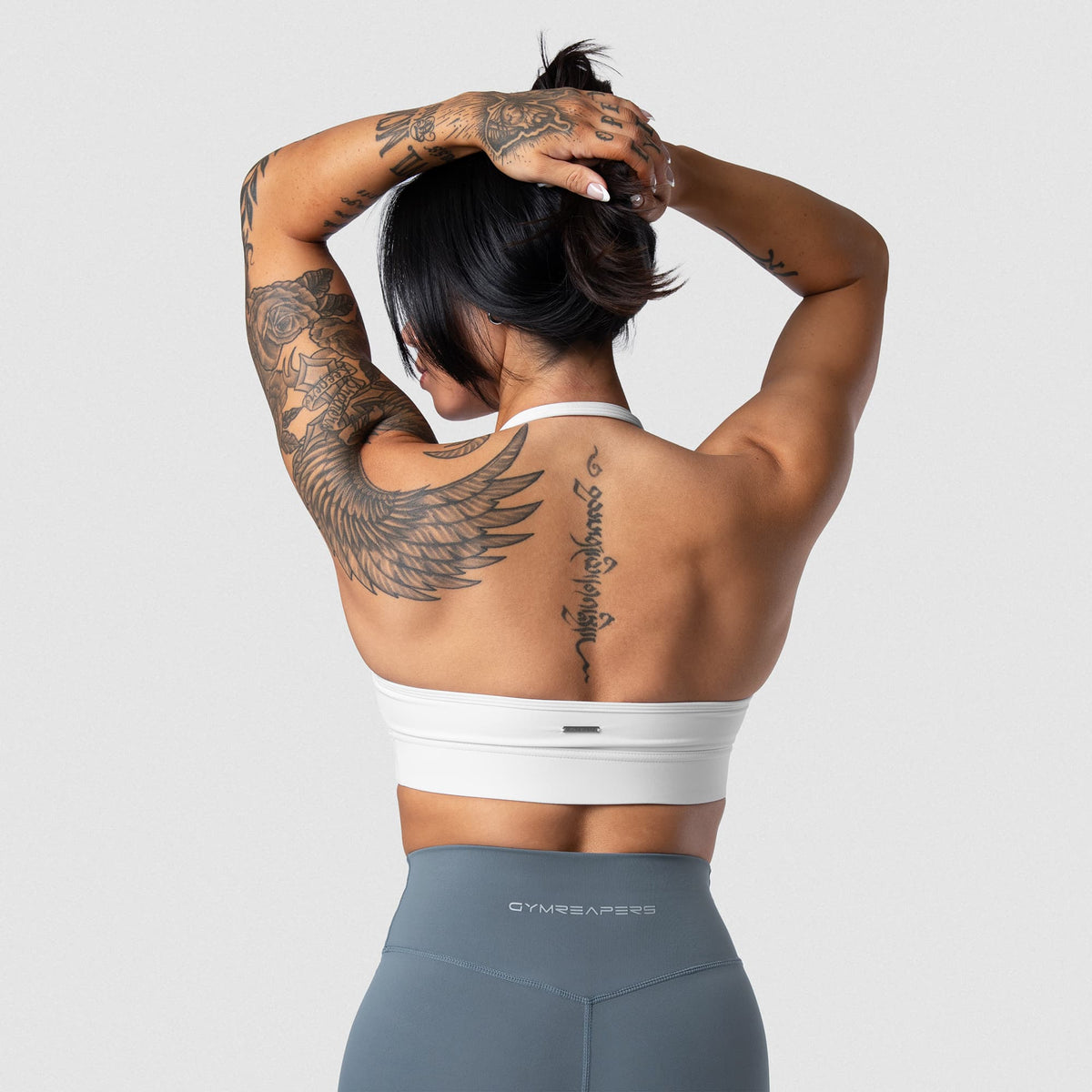 Female model wearing the Axis Twisted Halter Bra - White back view