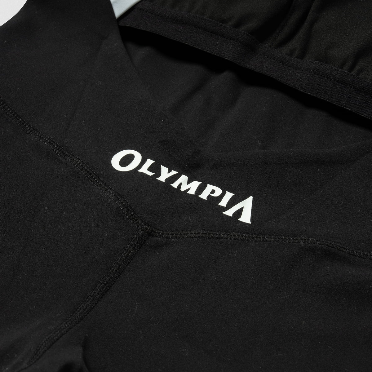 White "Olympia" wordmark logo on the back of the Olympia Bodysuit