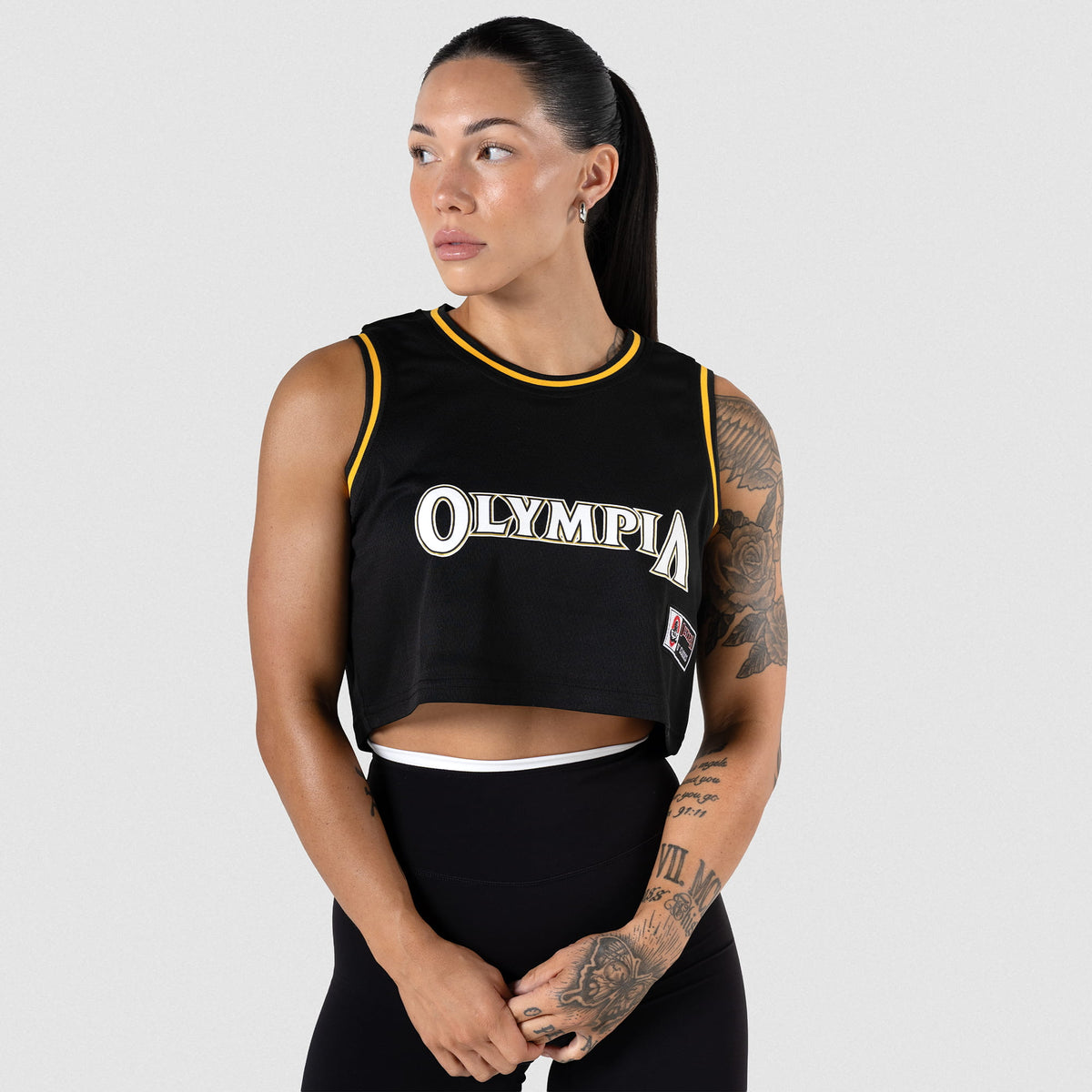 Champions Gold Crop Jersey | Female model wearing the cropped mesh, black jersey