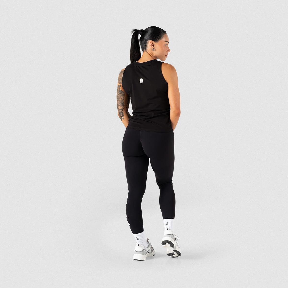 Full body back view of the women's full length Olympia training tank paired with black leggings