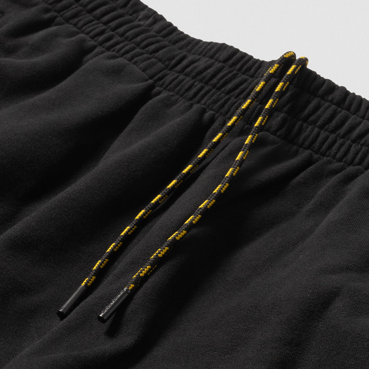 Alternating Black and Gold colored adjustable drawstrings on the Olympia Champions Gold Jogger
