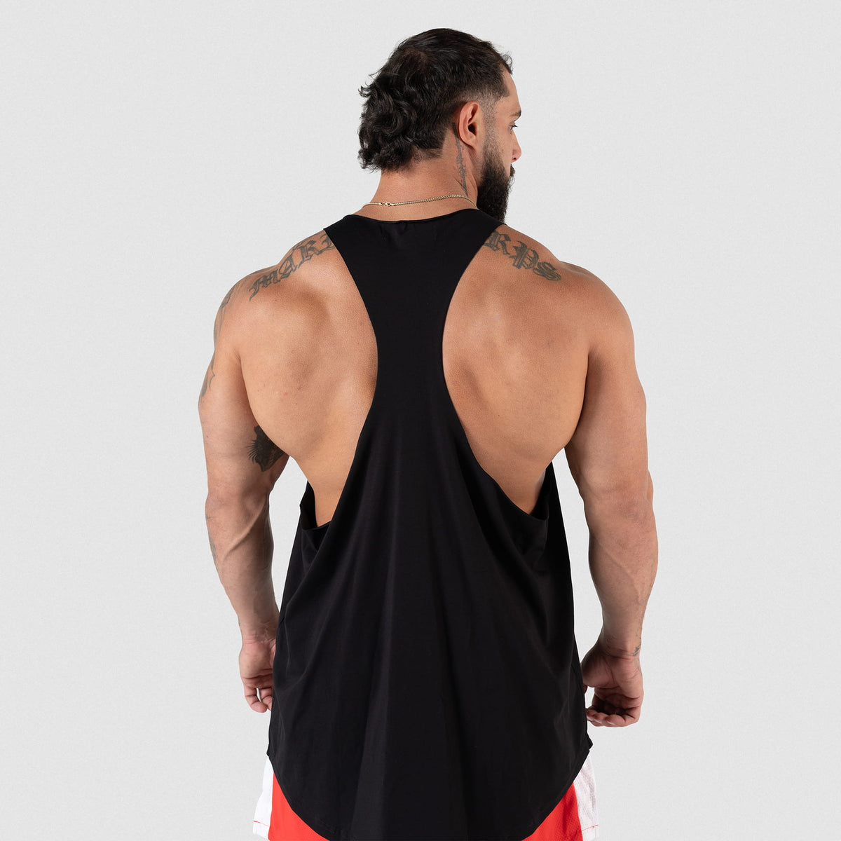 Torso back view of the Olympia International Division Stringer tank top in Black on a male model