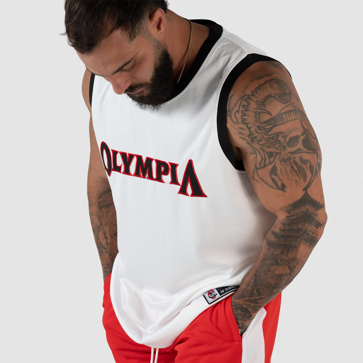 Signature Jersey | male model looking down while wearing the white basketball inspired jersey with "Olympia" written across the chest