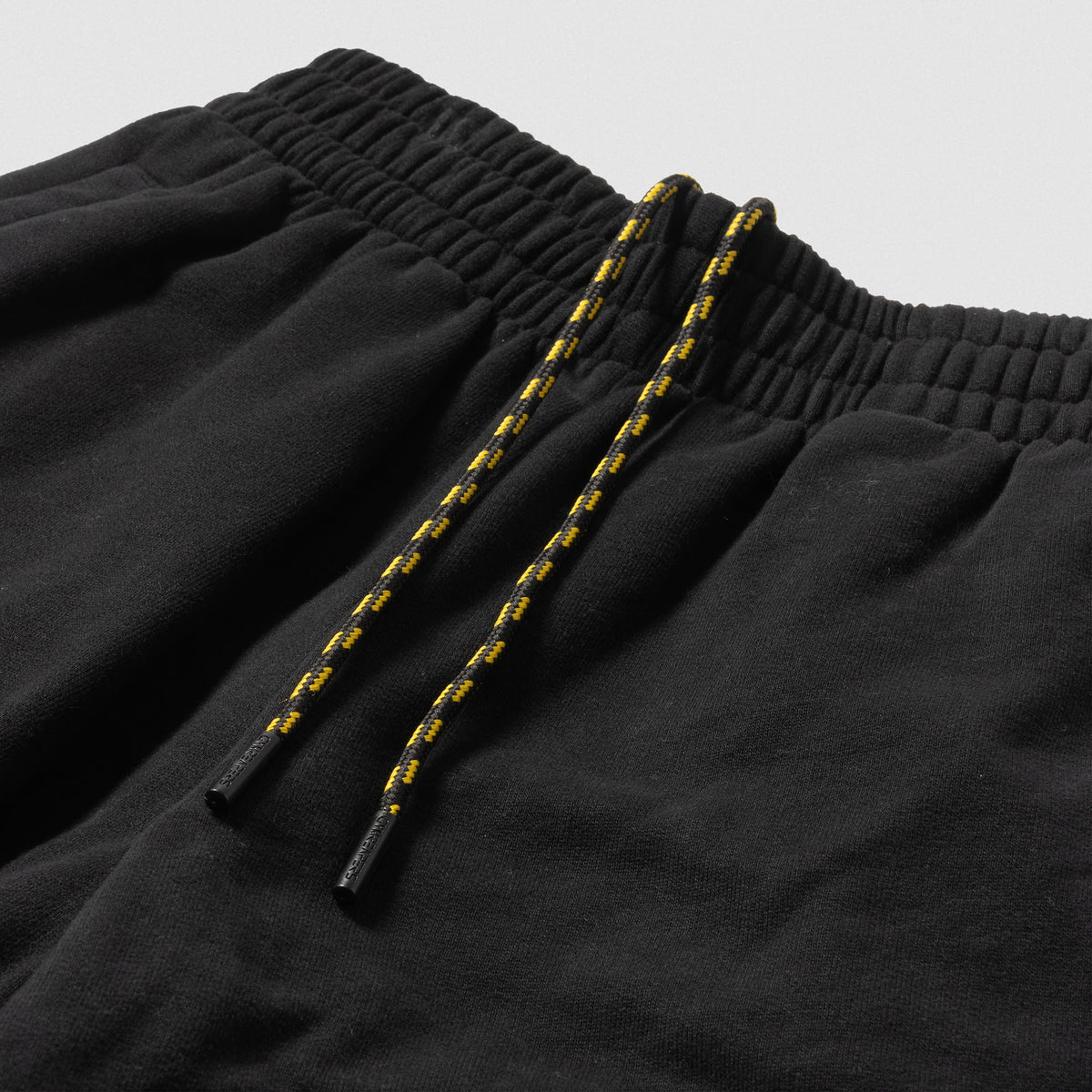 Close up of alternating black and gold adjustable drawstring chord on the women's Champions Gold Wide-Leg Jogger
