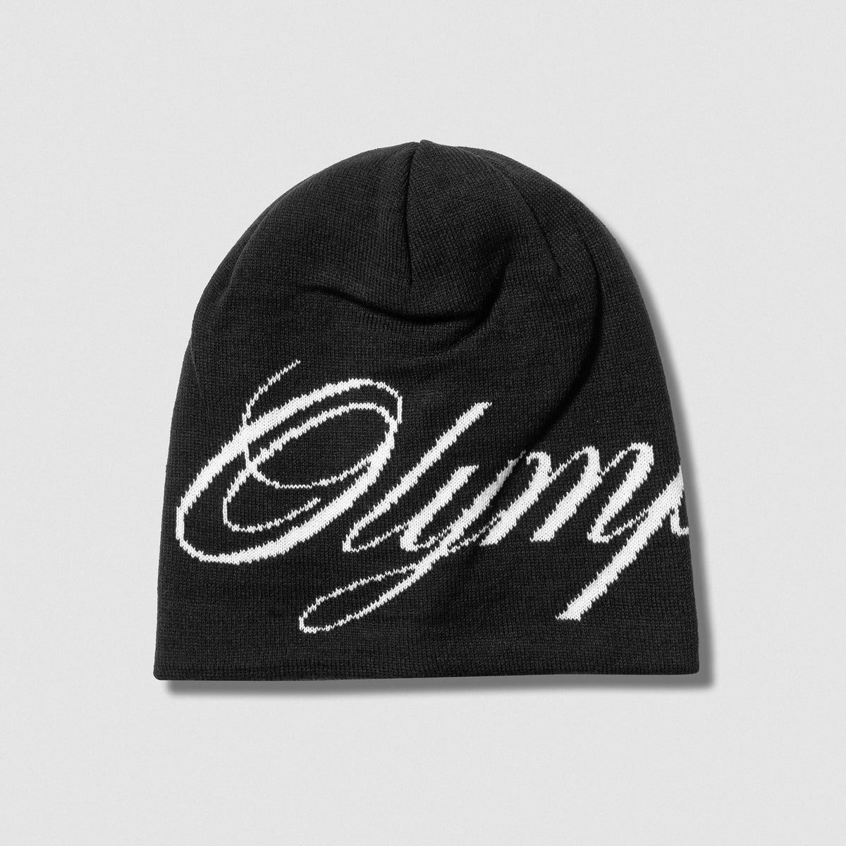 Flat lay of Black Olympia Script Skull Cap beanie and white Olympia text against gray background