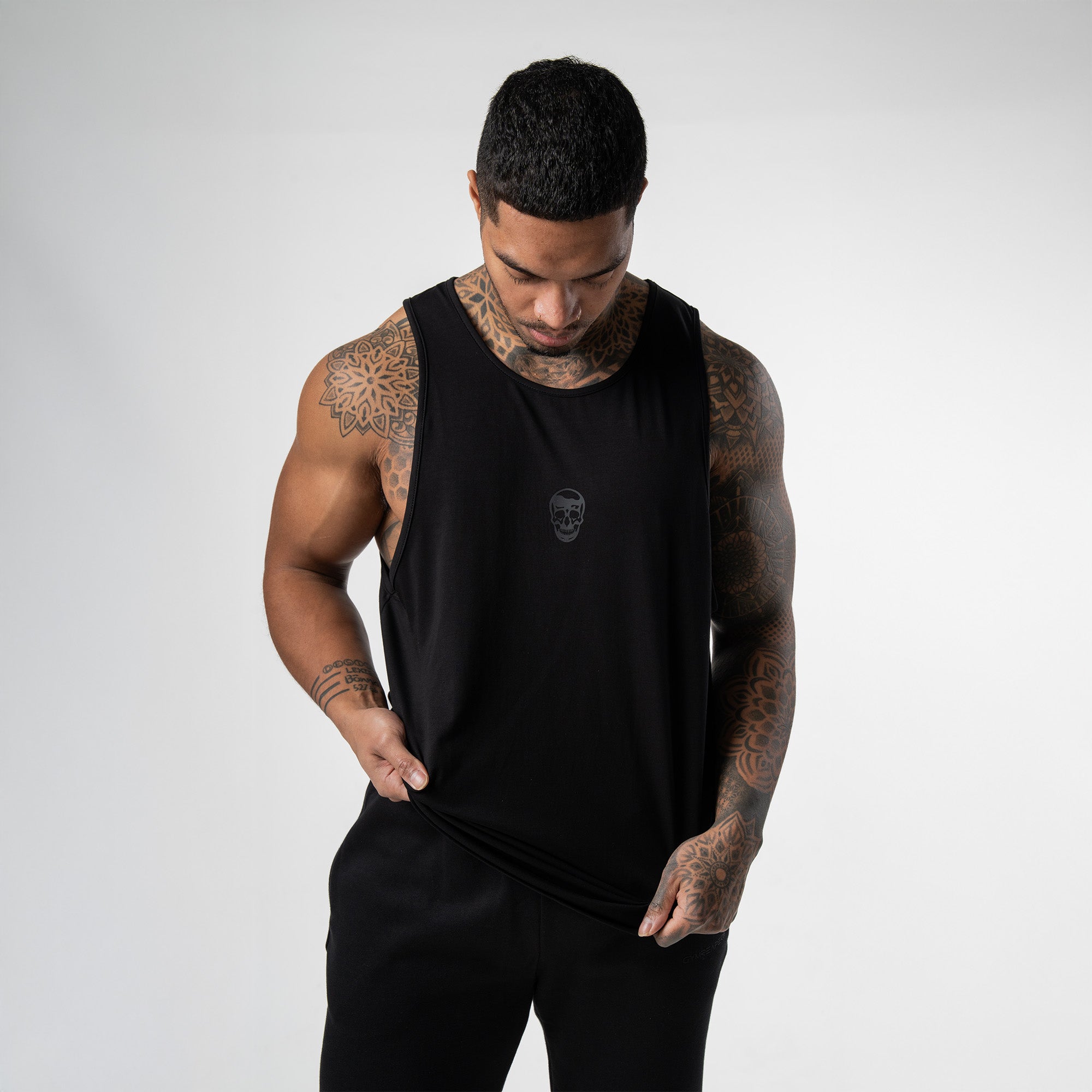 Athlete wearing black axis scoop hem tank front view