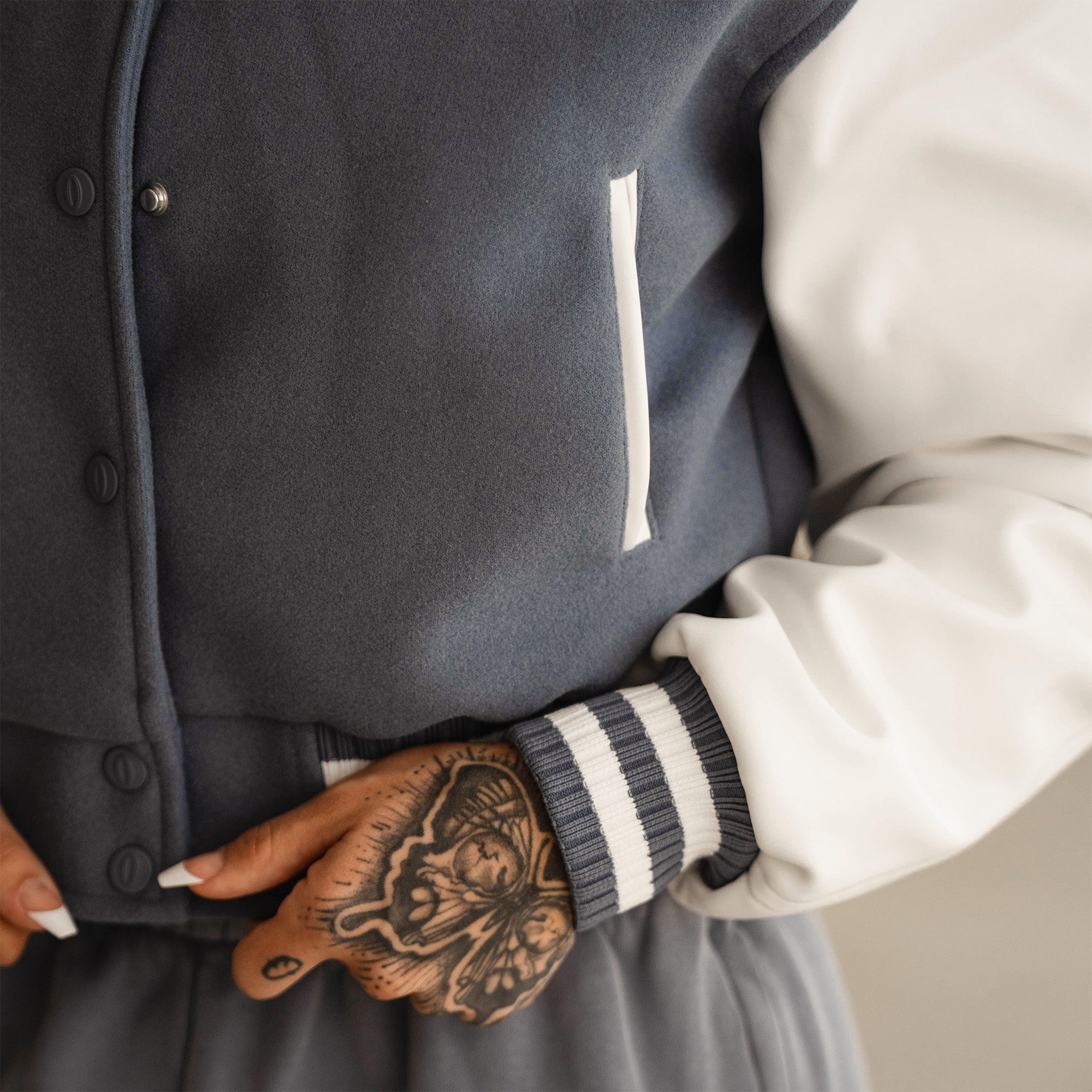 cropped varsity jacket on athlete close up of pocket and and sleeve cuff detail