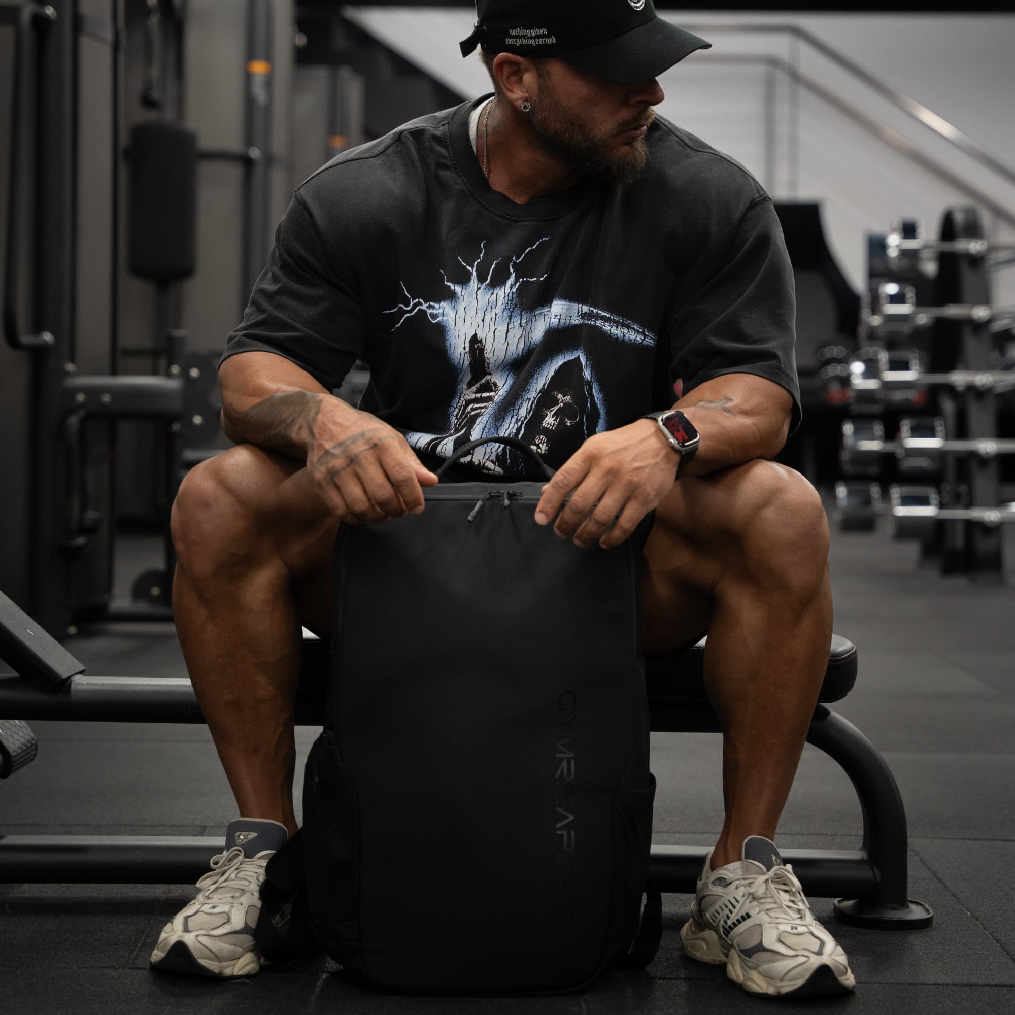athlete sitting on gym bench holding the vanguard backpack