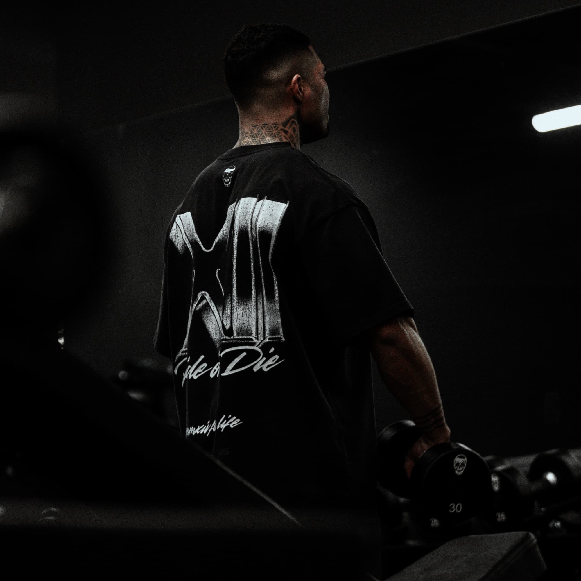 Athlete doing lateral raises while wearing the 12th Anniversary Tee - Ride or Die