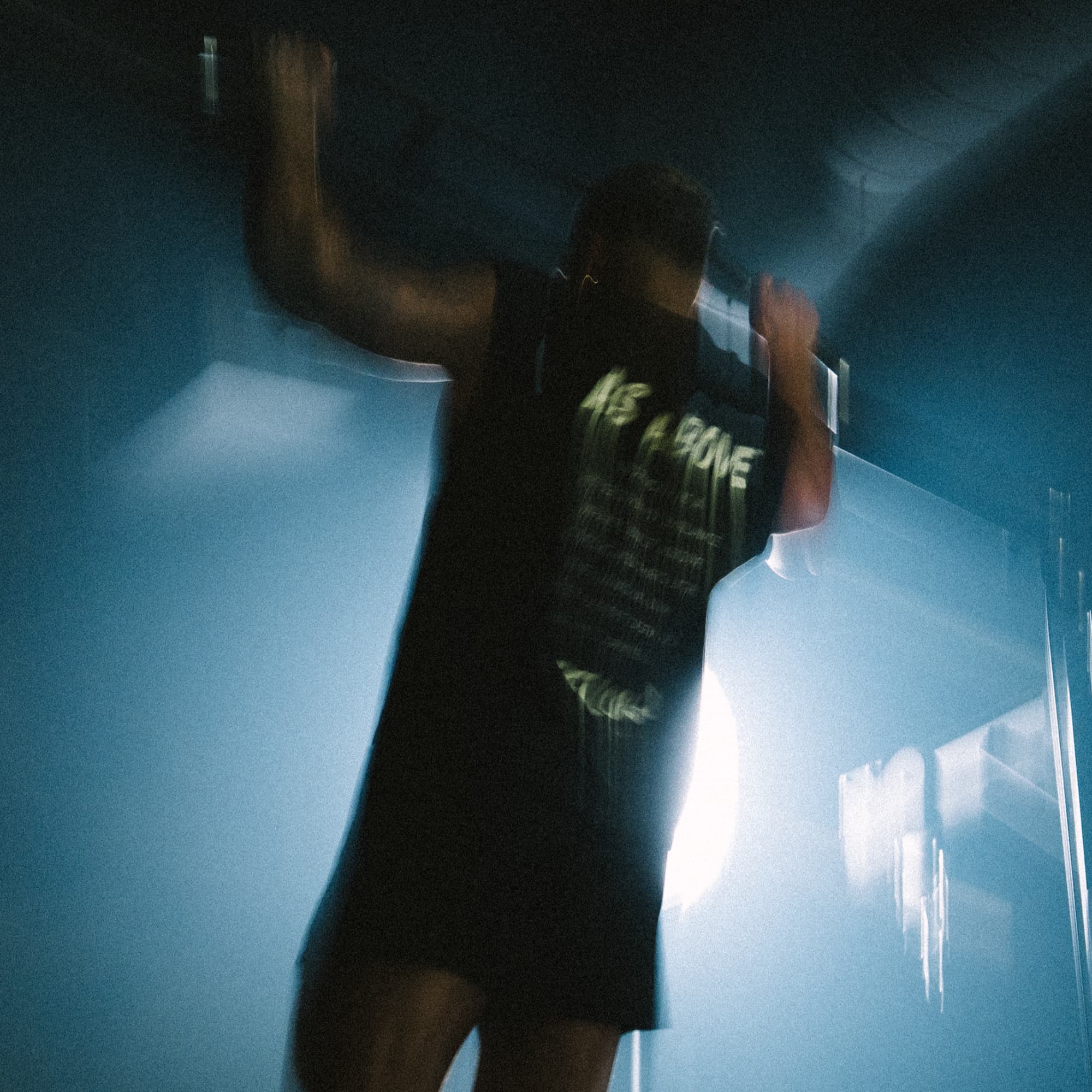 lifestyle image of athlete doing pull ups while wearing the manifesto cut off.