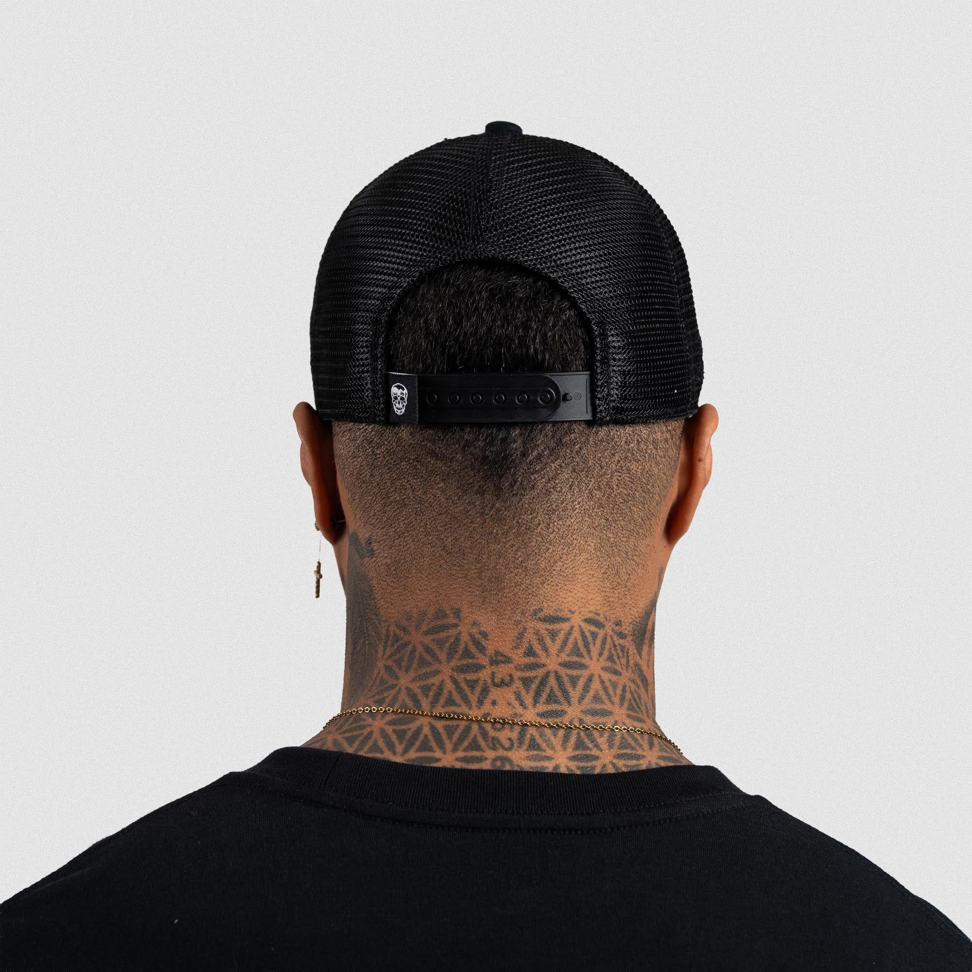 Athlete wearing Black/Black 5-Panel Initial Trucker Hat back view