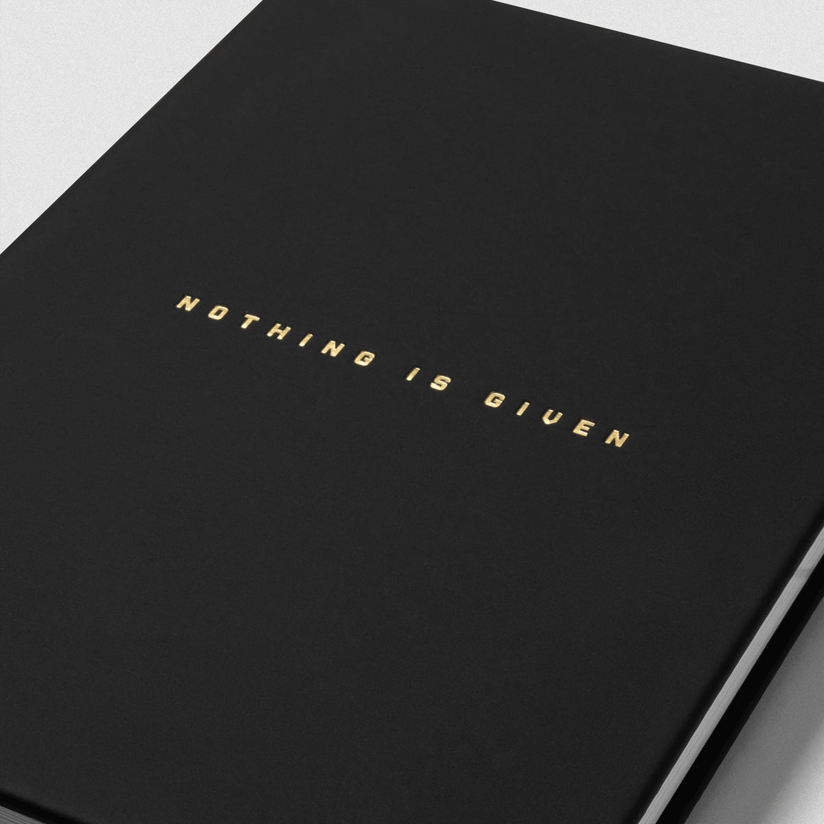 Women's Workout Journal in Black – Cover Text Detail with Gold text that says Nothing is Given