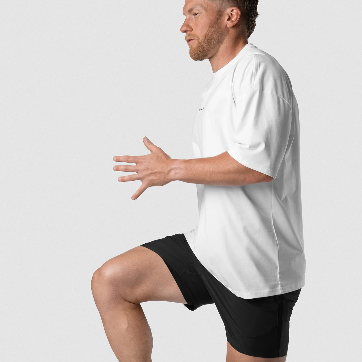 Male model wearing the Axis Box Tee - White side and movement view