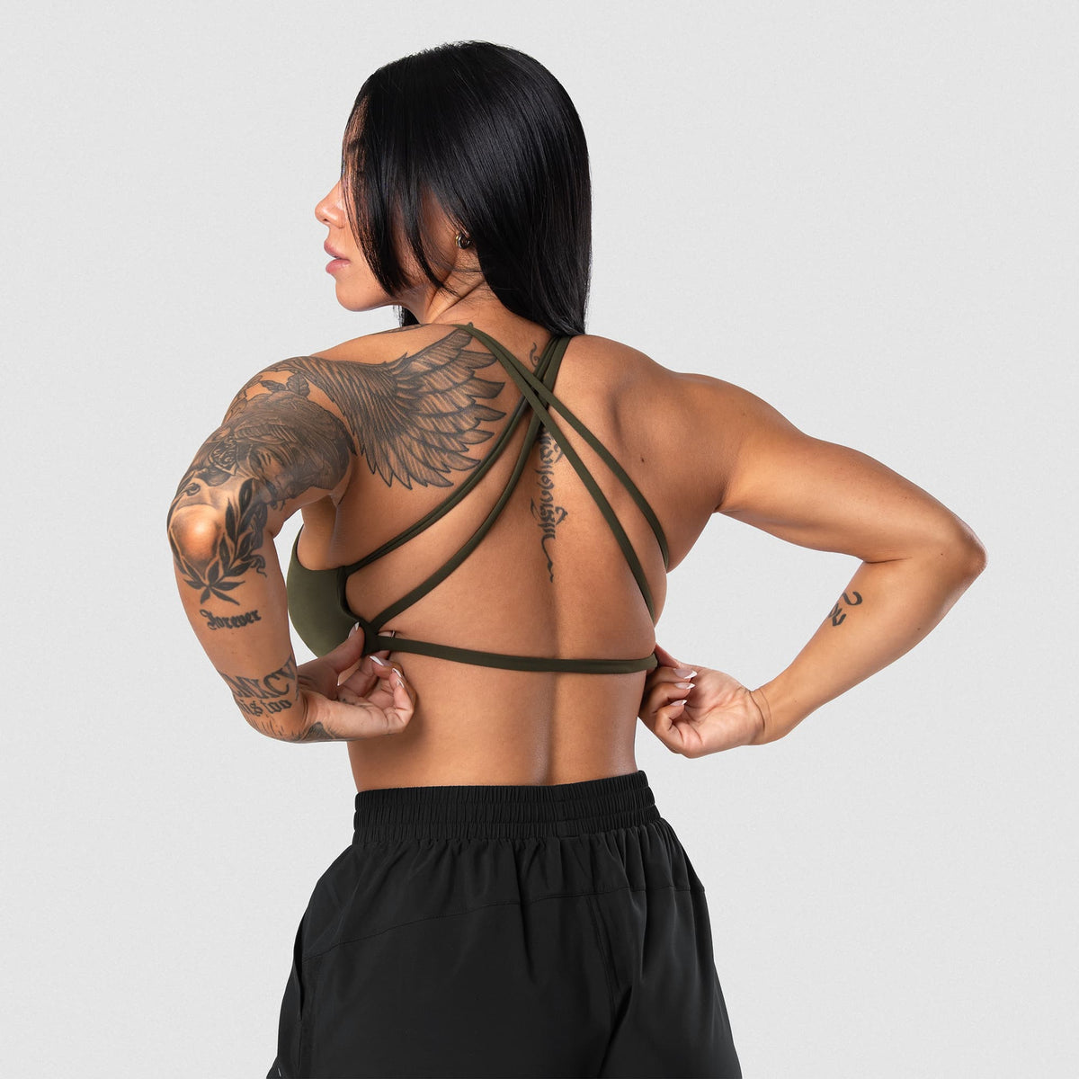 Female model wearing the Axis Open Back Bra - OD Green back view
