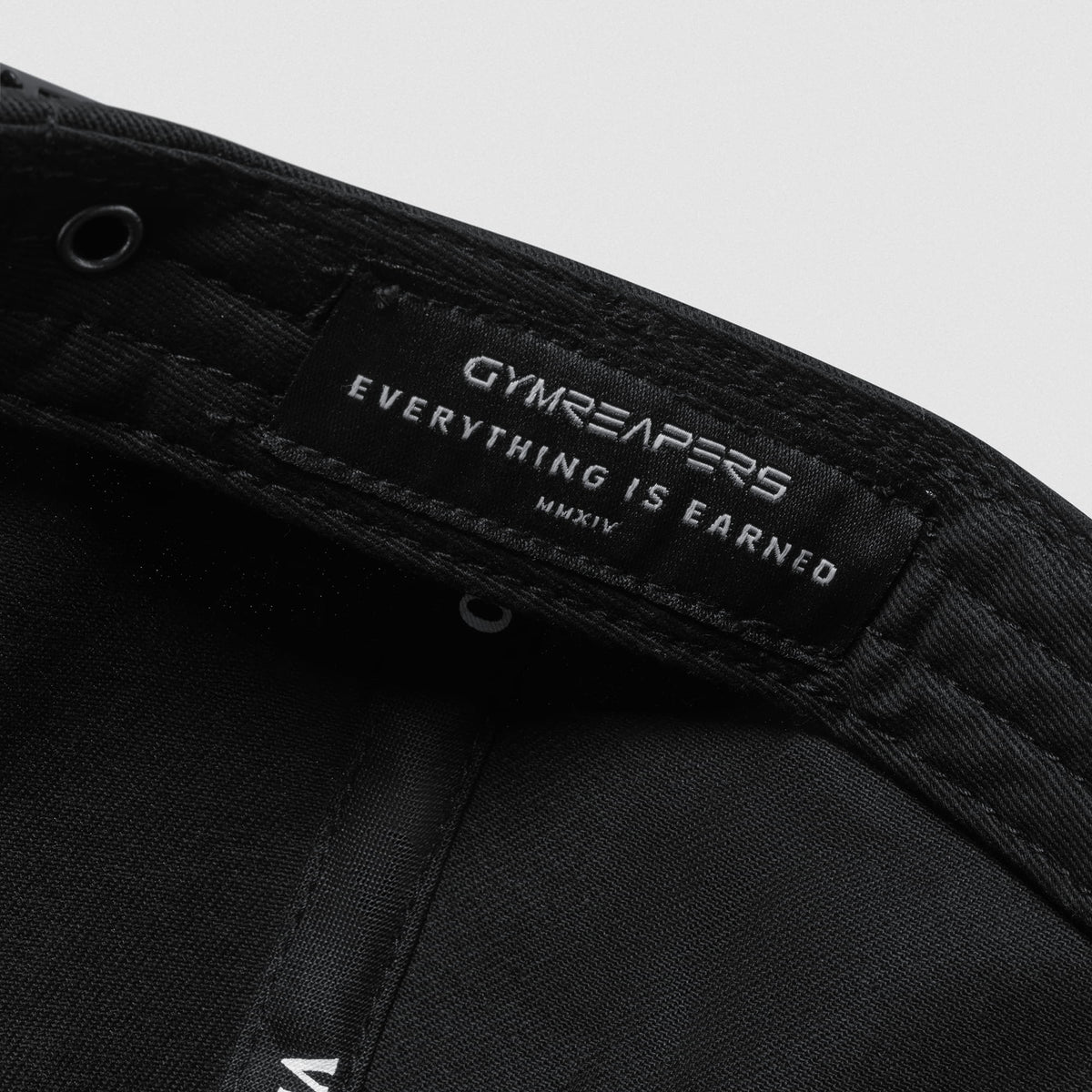 Inside tag of the Micro Joe Dad Hat that says GYMREAPERS Everything is Earned MMXIV