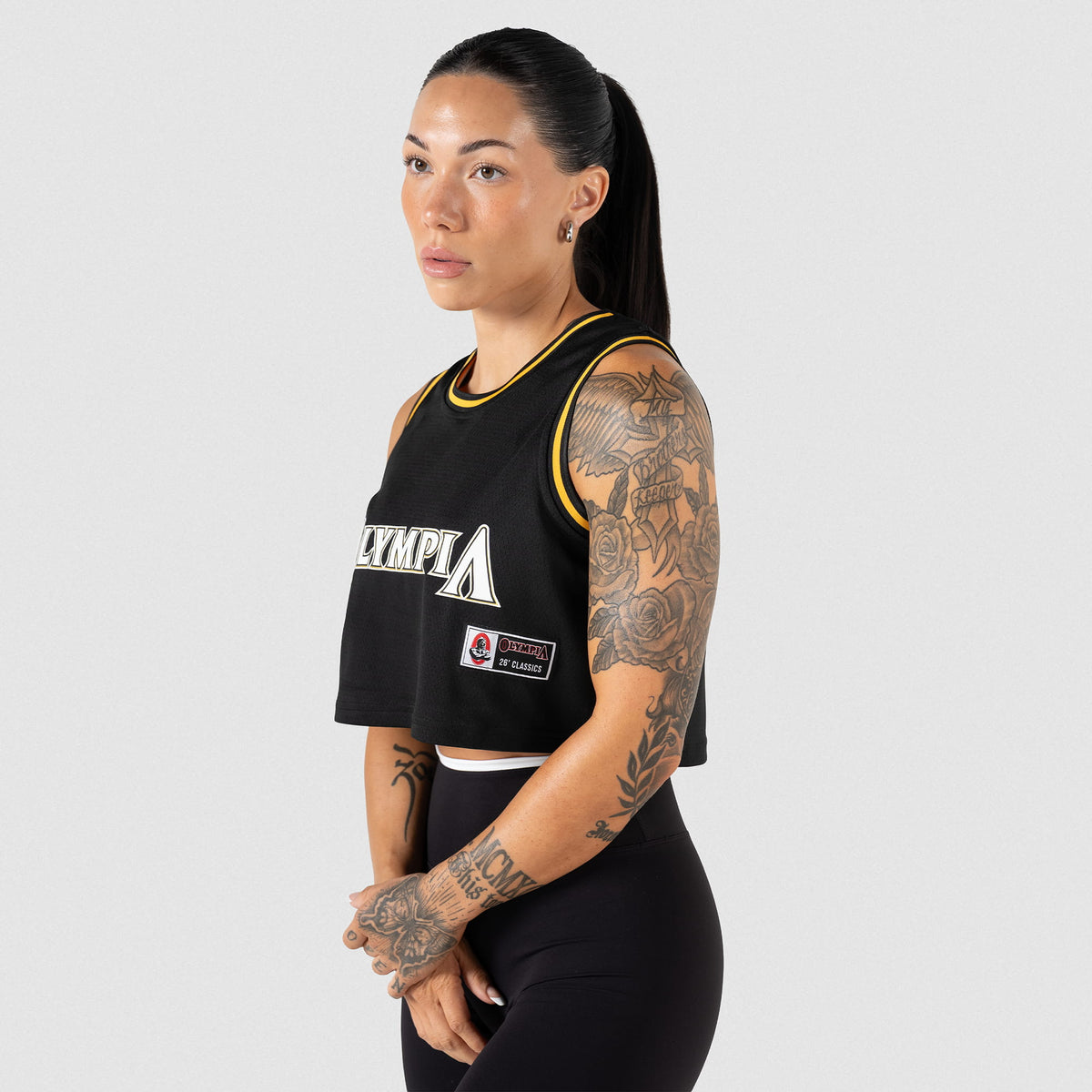Champions Gold Crop Jersey | Side view of black jersey showcasing the Olympia Jersey tag and logo