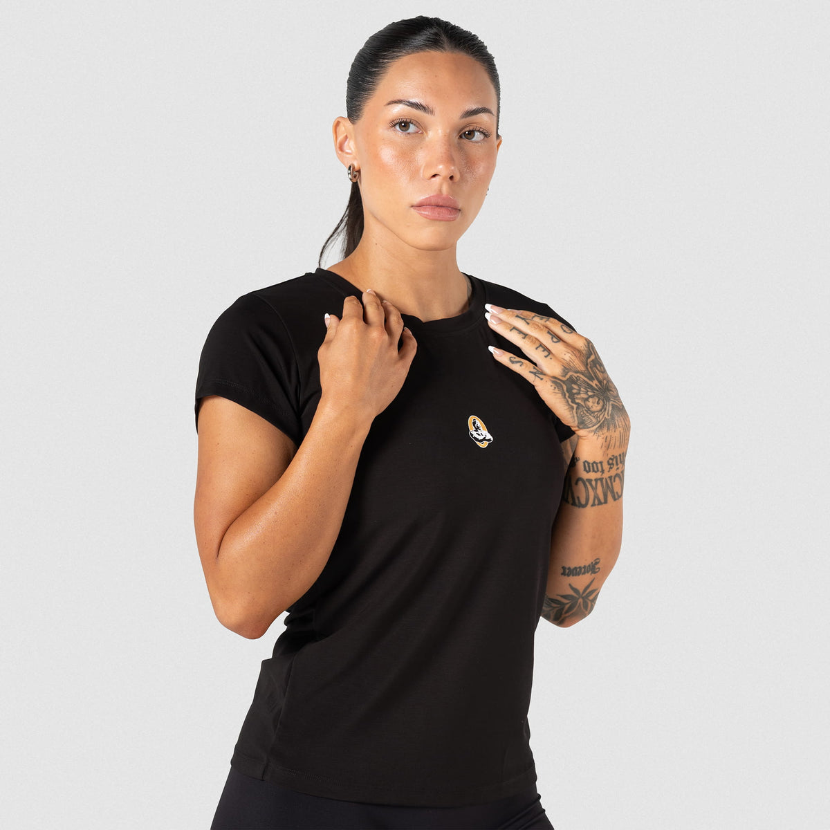 Female model wearing the Champions Gold Full Length Training Tee with a small Champions Gold logo on the center chest