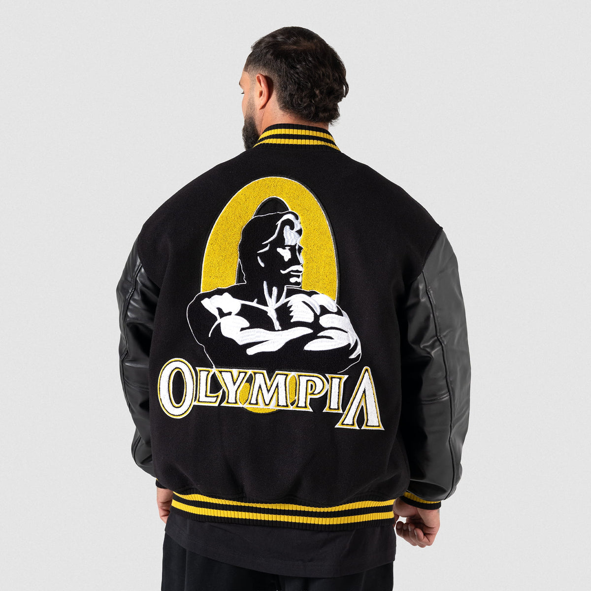 Olympia Champions Gold Varsity Jacket in Black – On Model, Back View