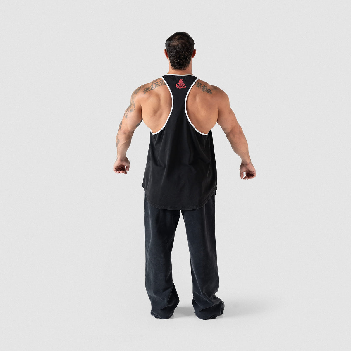 Full body back view of the Championship Stringer black tank top paired with black sweatpants