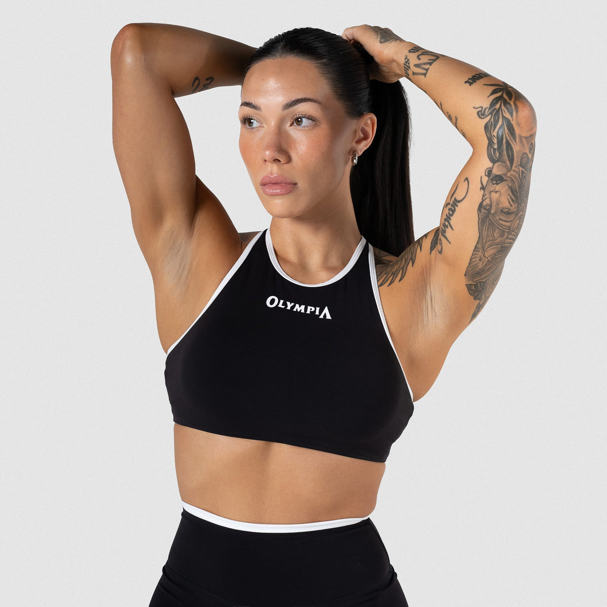 Female model wearing the Olympia High Neck Bra with Black/White contrasting details and 
