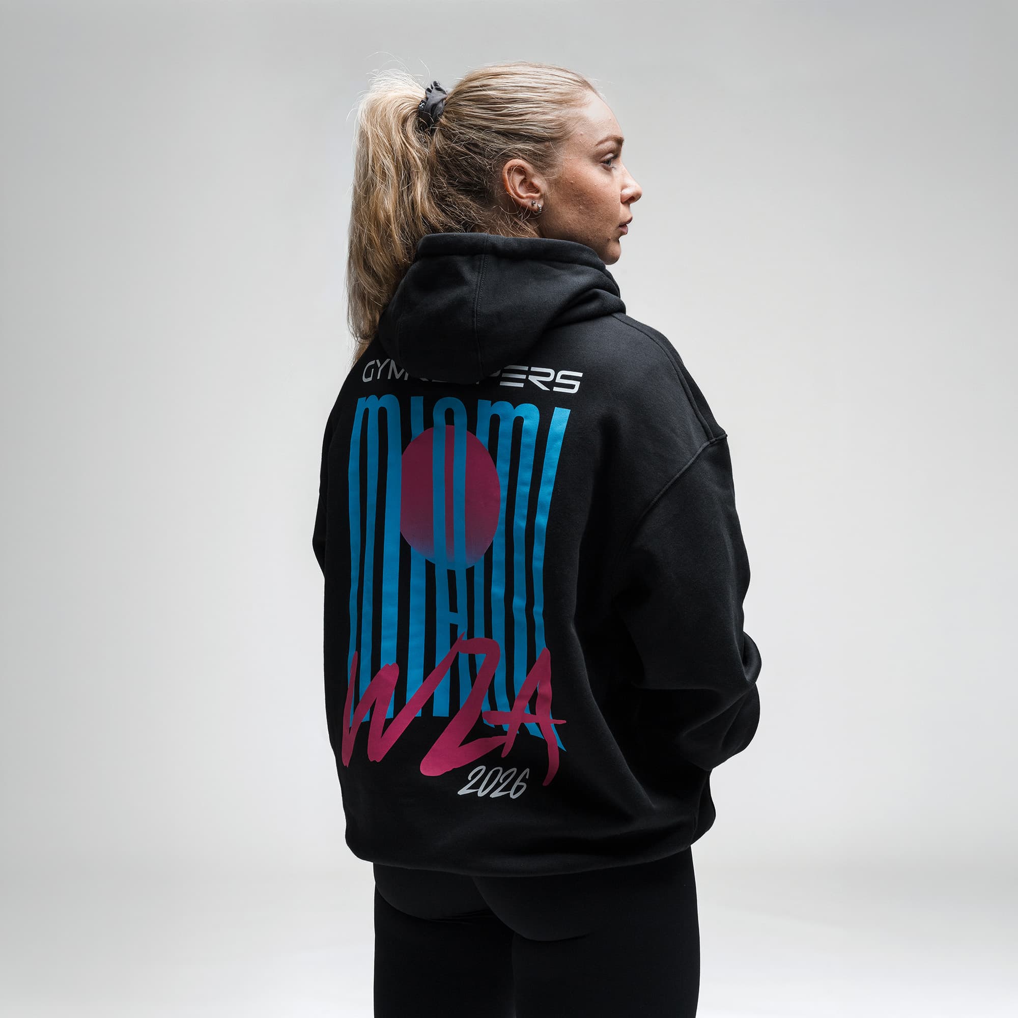 Female athlete wearing the Neon Horizon Hoodie half body shot back view