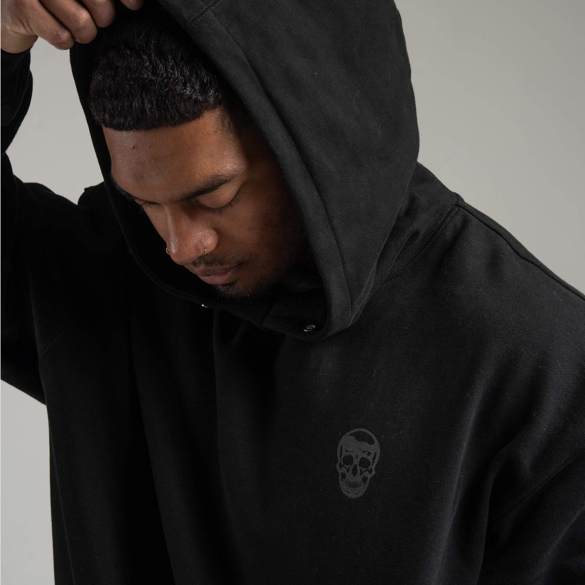 athlete wearing Black/Black Heavyweight Hoodie with hood on