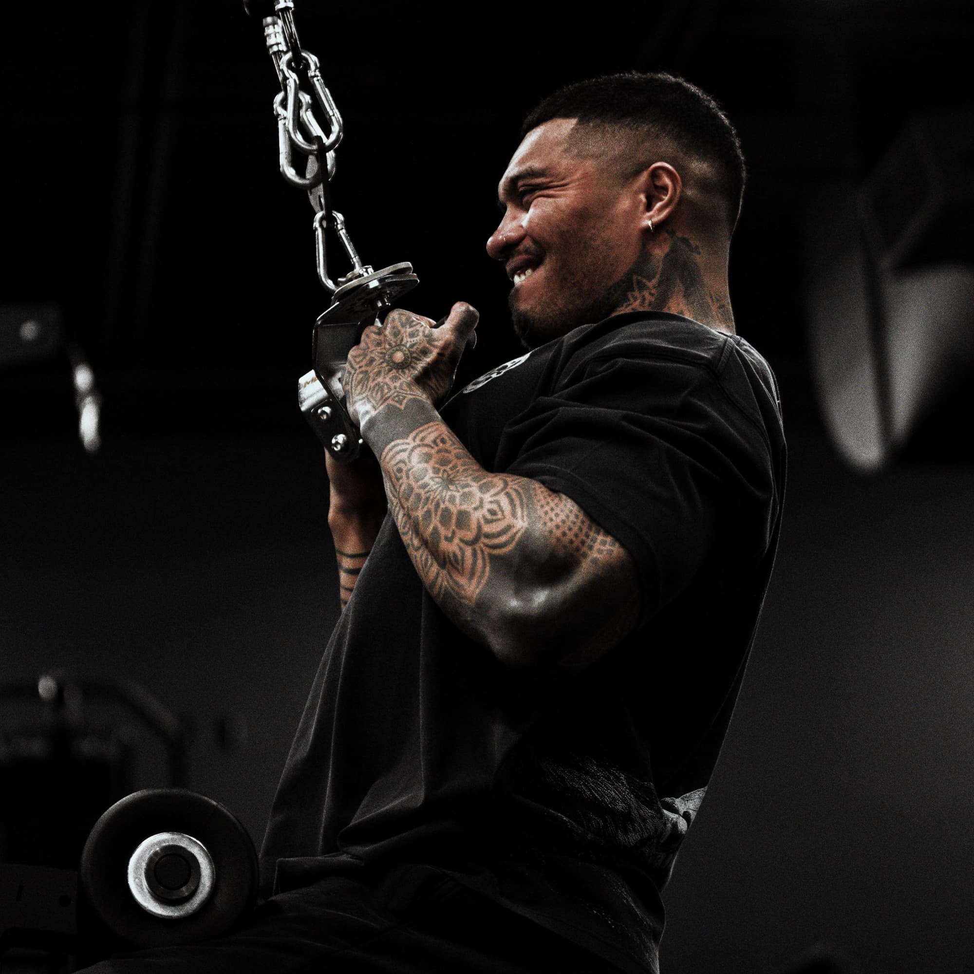 Athlete doing lat pulldowns while wearing 12th Anniversary Tee - Never Finished