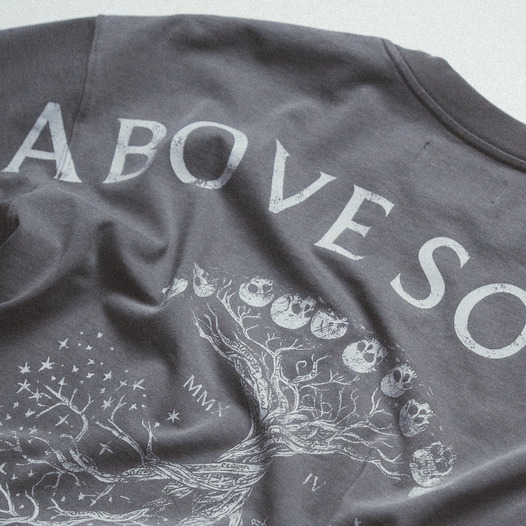 Close-up shot of the Reflection Graphic Tee’s distressed back print, highlighting the cracked ink texture.