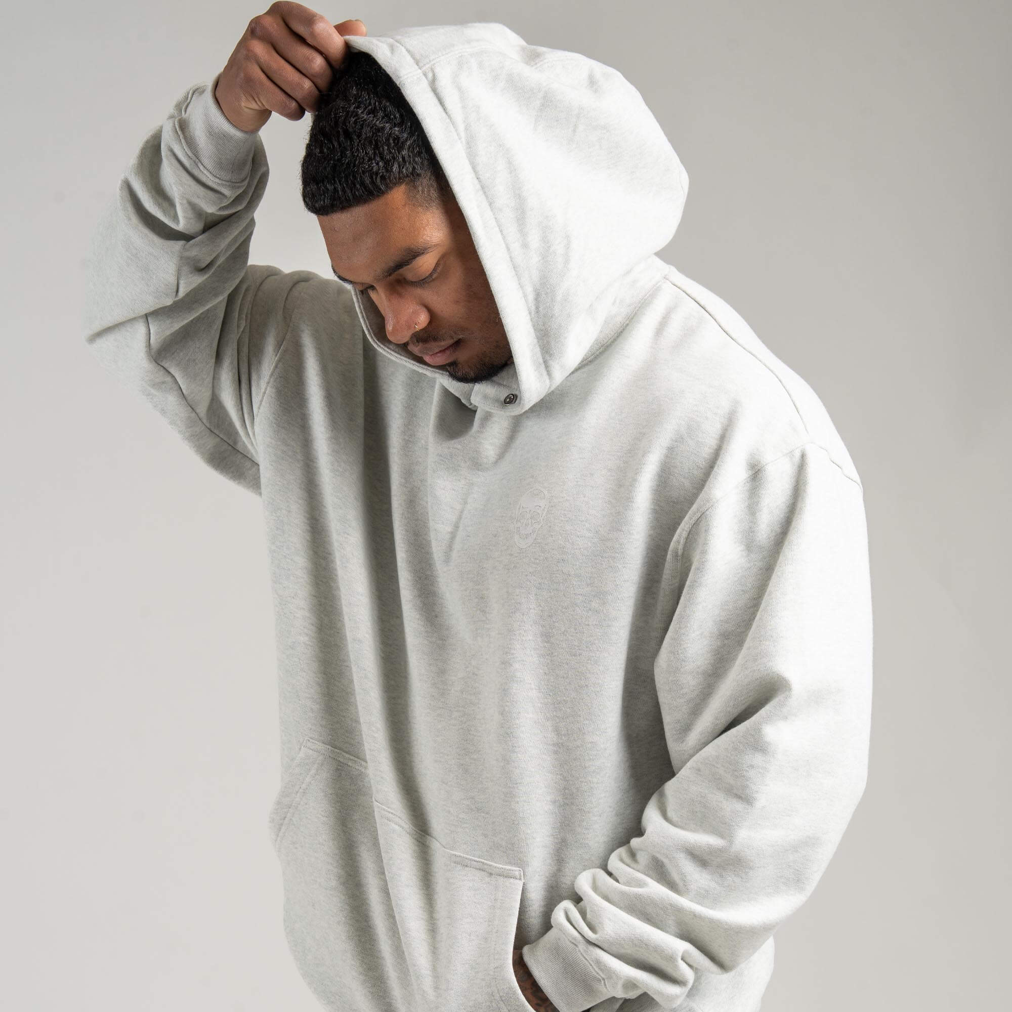 athlete wearing Light Heather Gray Heavyweight Hoodie with hood on