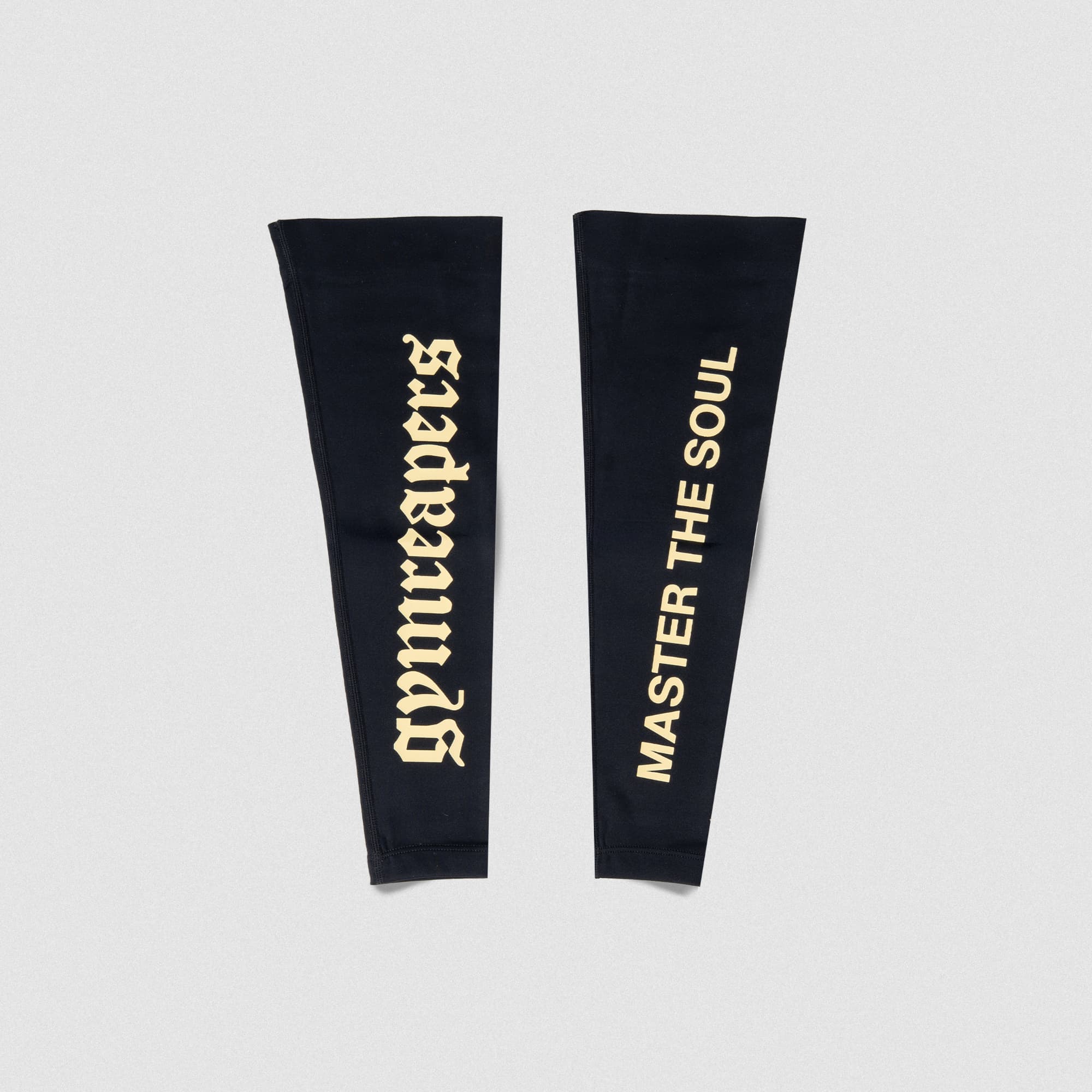 Front view of Gymreapers Master the Soul Arm Warmers featuring bold vertical logos on black fabric