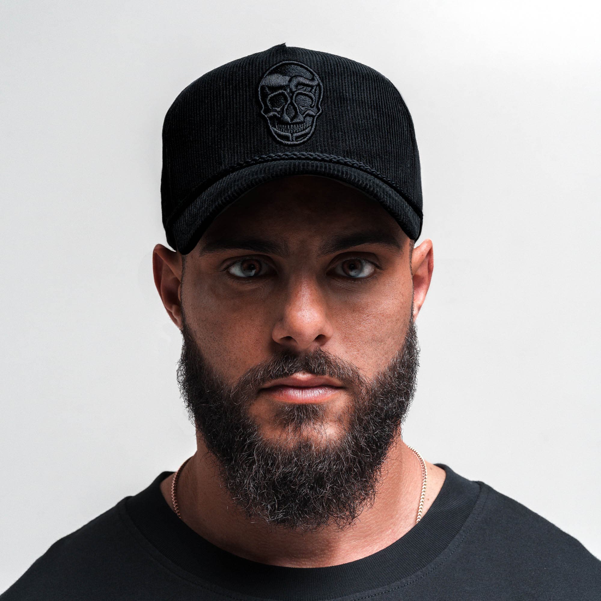 Athlete wearing Corduroy 5-Panel Skull Hat - Black/Black front view