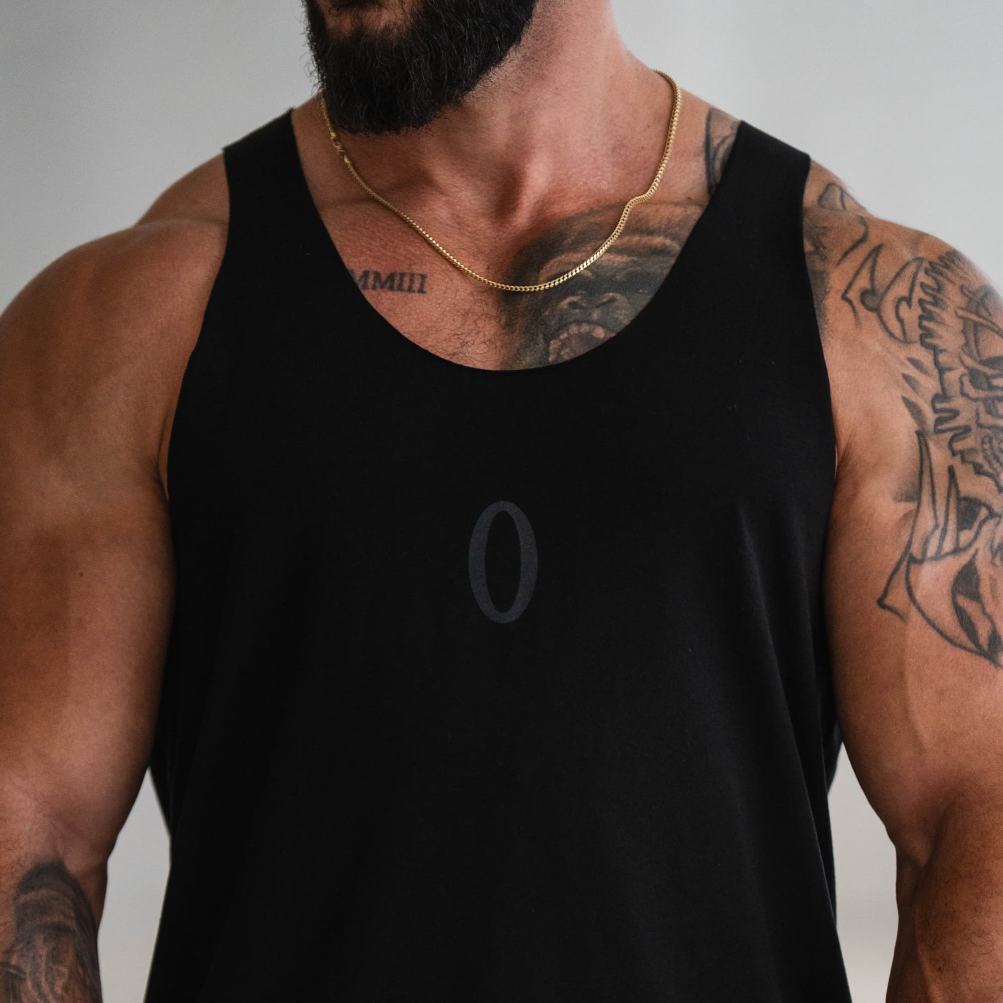 Close-up of chest area on model showing tonal “O” logo on Raw Hem Olympia Stringer.