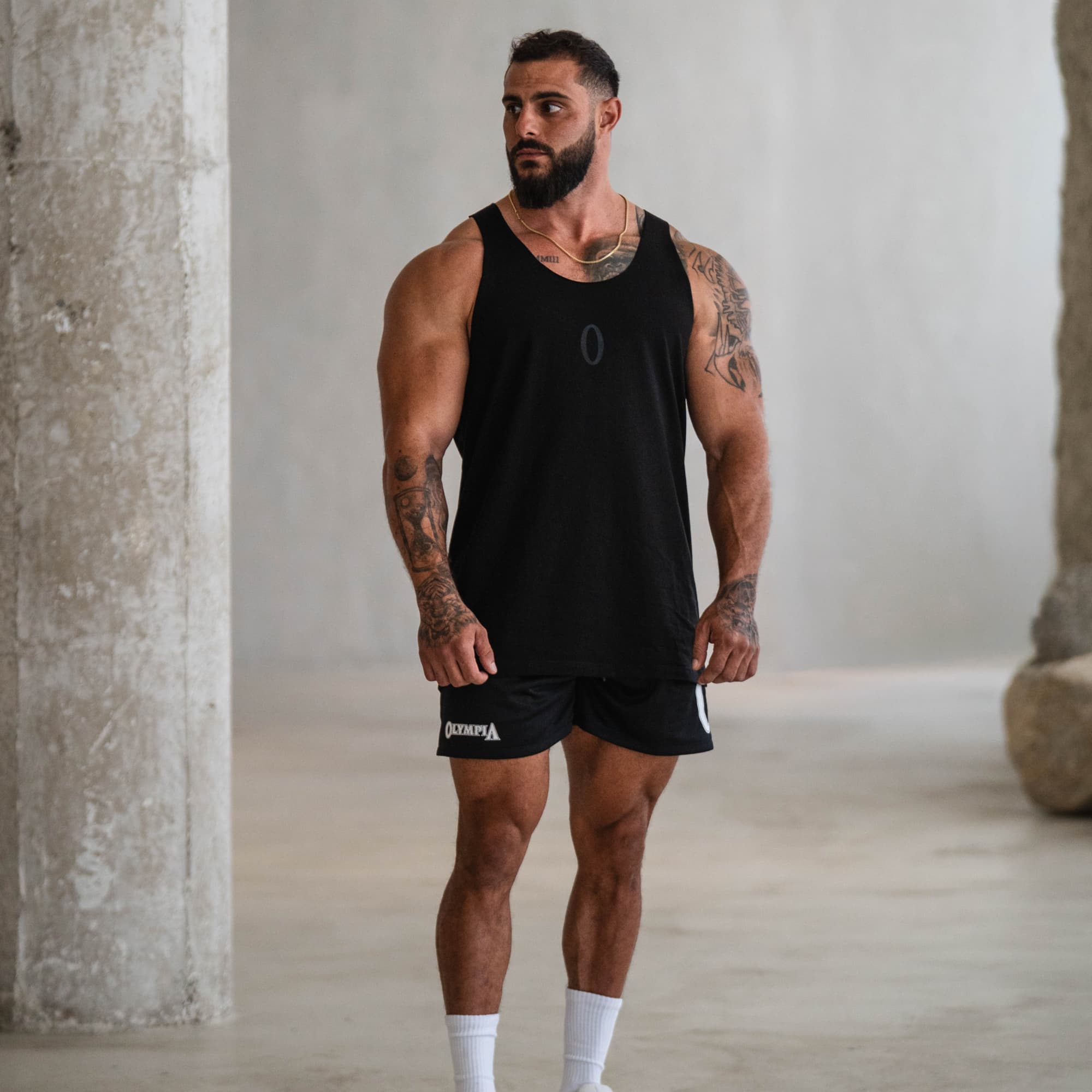 Model wearing Raw Hem Olympia Stringer front view with black shorts and white socks.