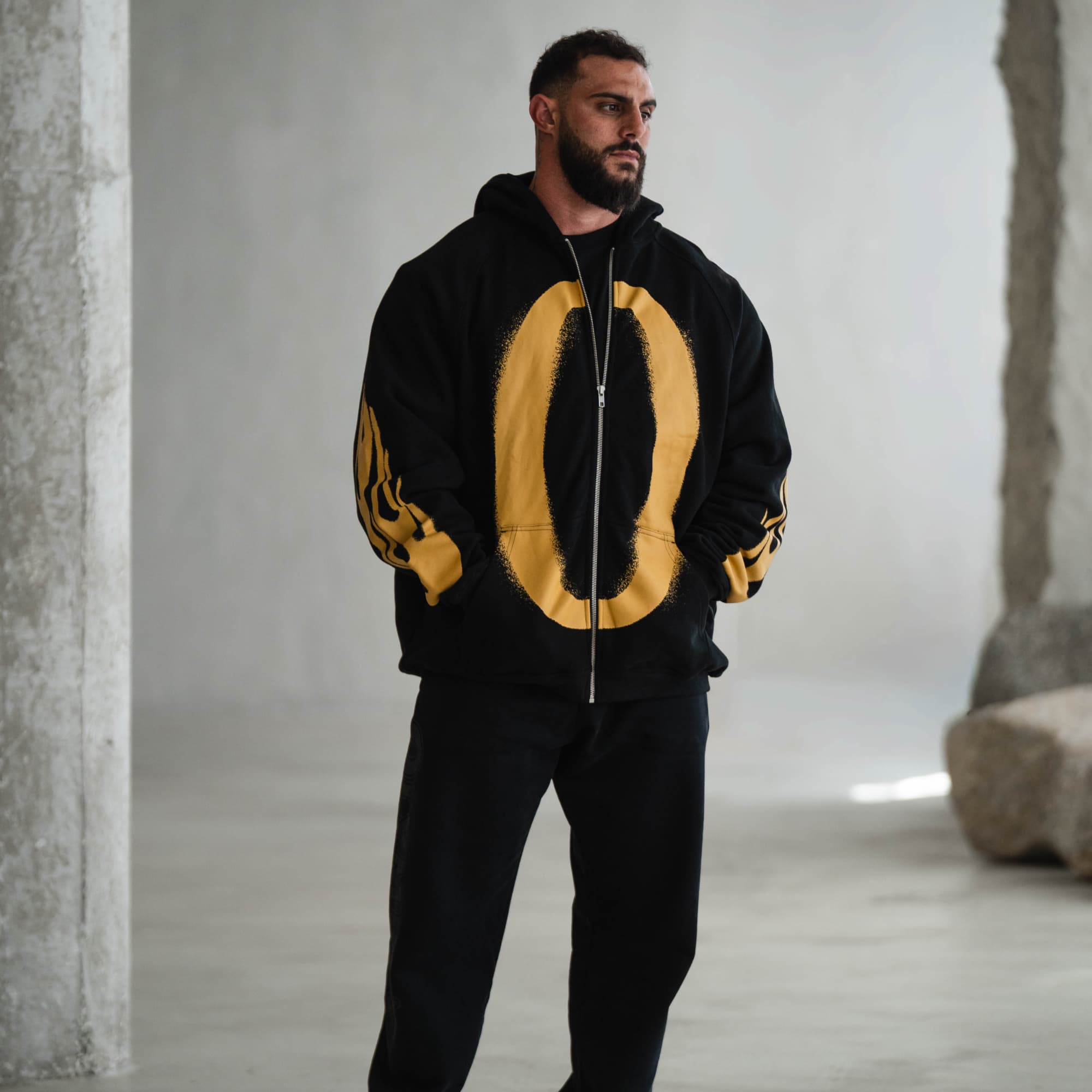 Model wearing the Ring of Fire Zip-Up Hoodie, full body front view with hands in pockets