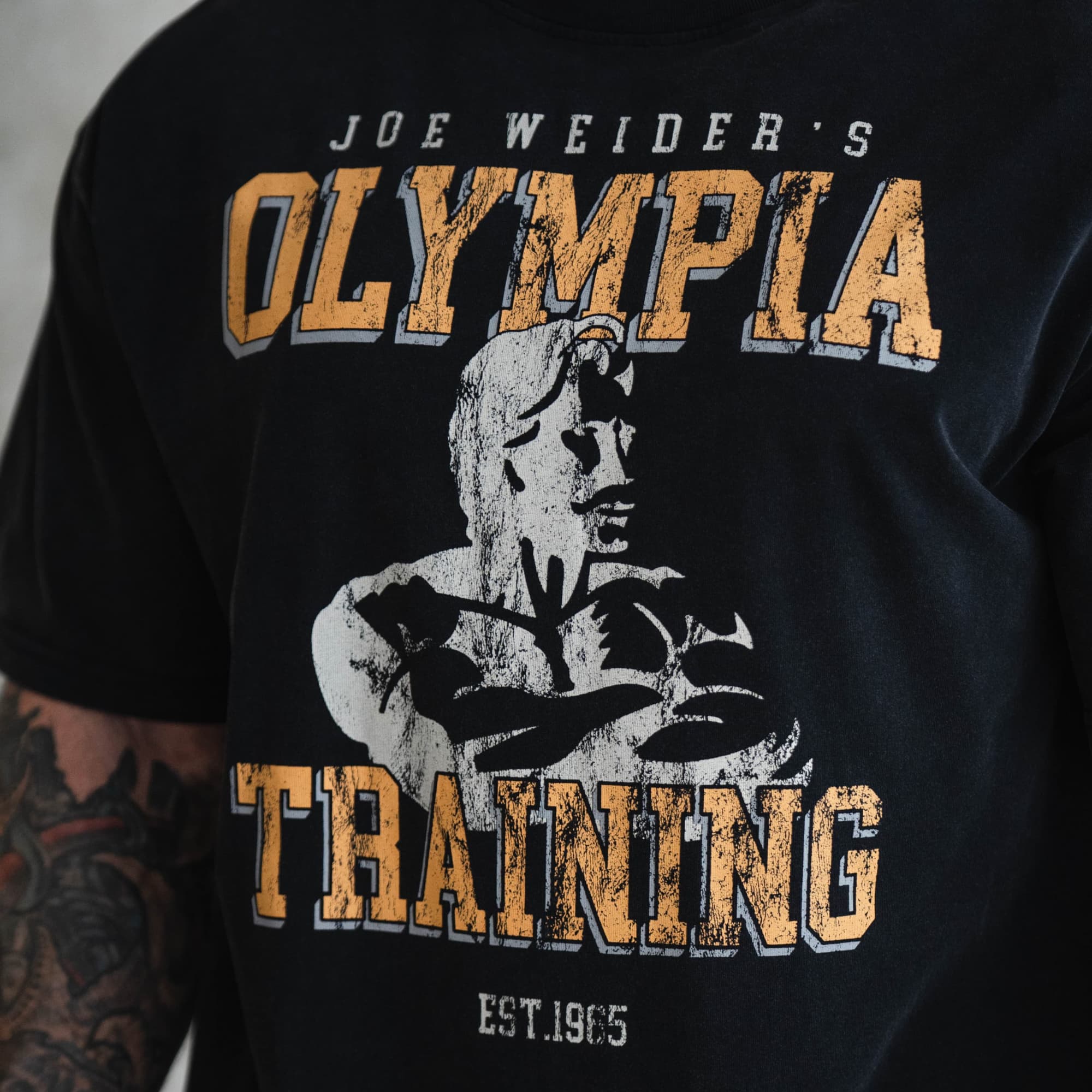 close up lifestyle shot of athlete wearing olympia training tee showcasing graphic