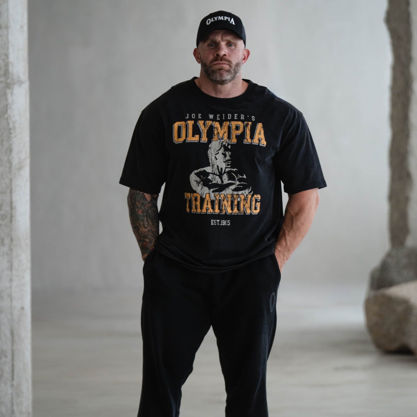lifestyle shot of athlete wearing olympia training tee with hands in pocket
