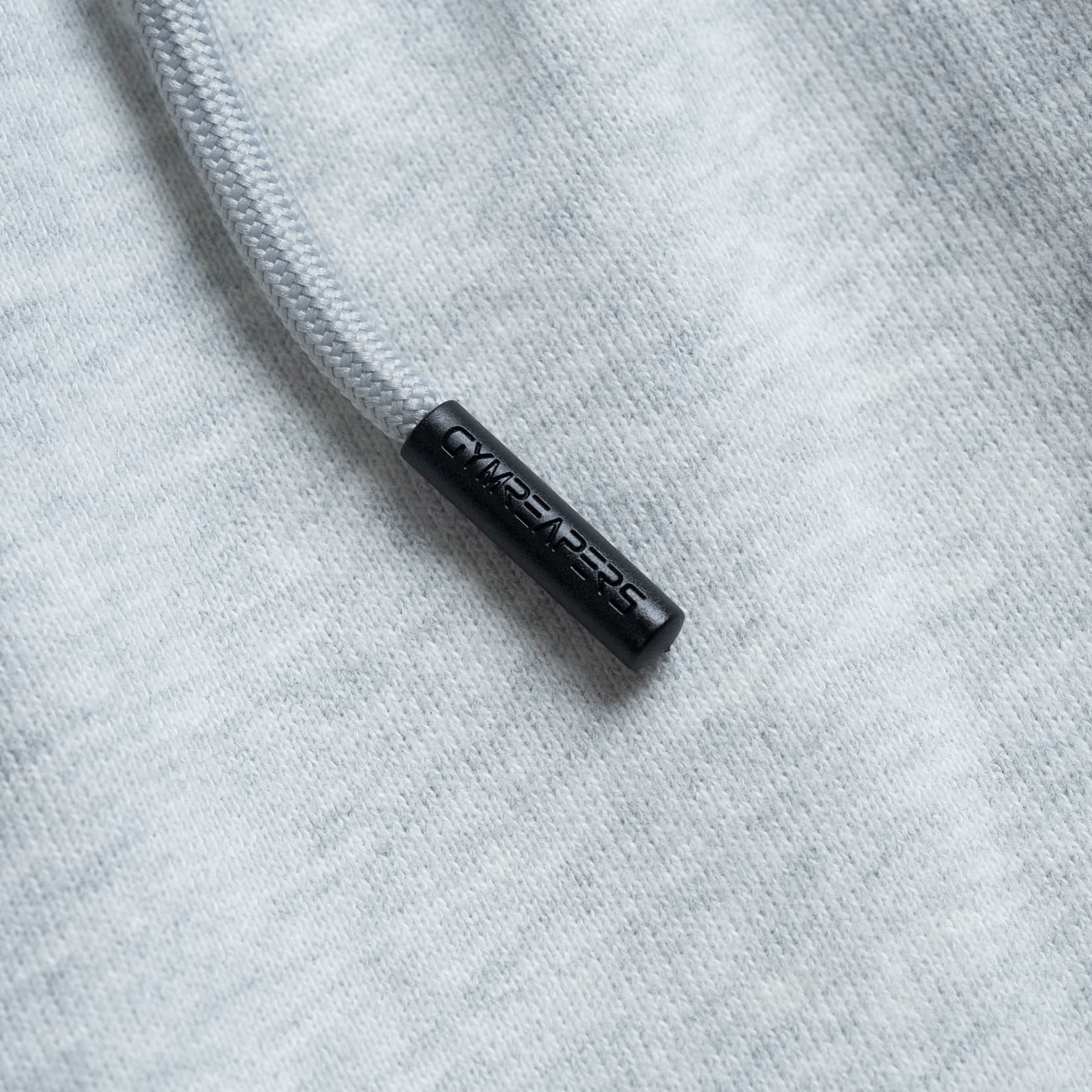 Close-up view of the drawcord aglet with “Gymreapers” branding in black detail.