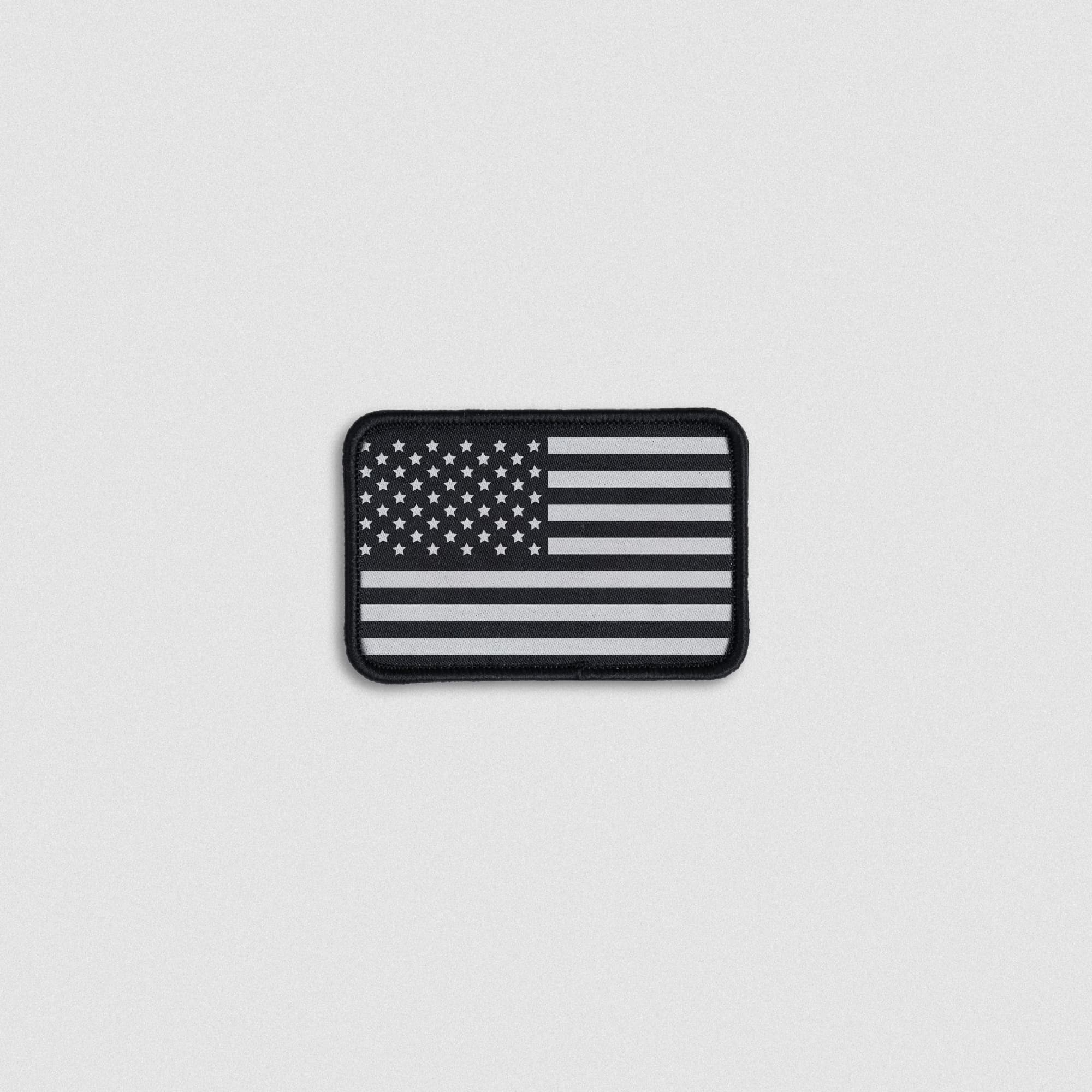 black USA flag patch with embroidered details and rectangular shape, featuring hook and loop backing for easy attachment.