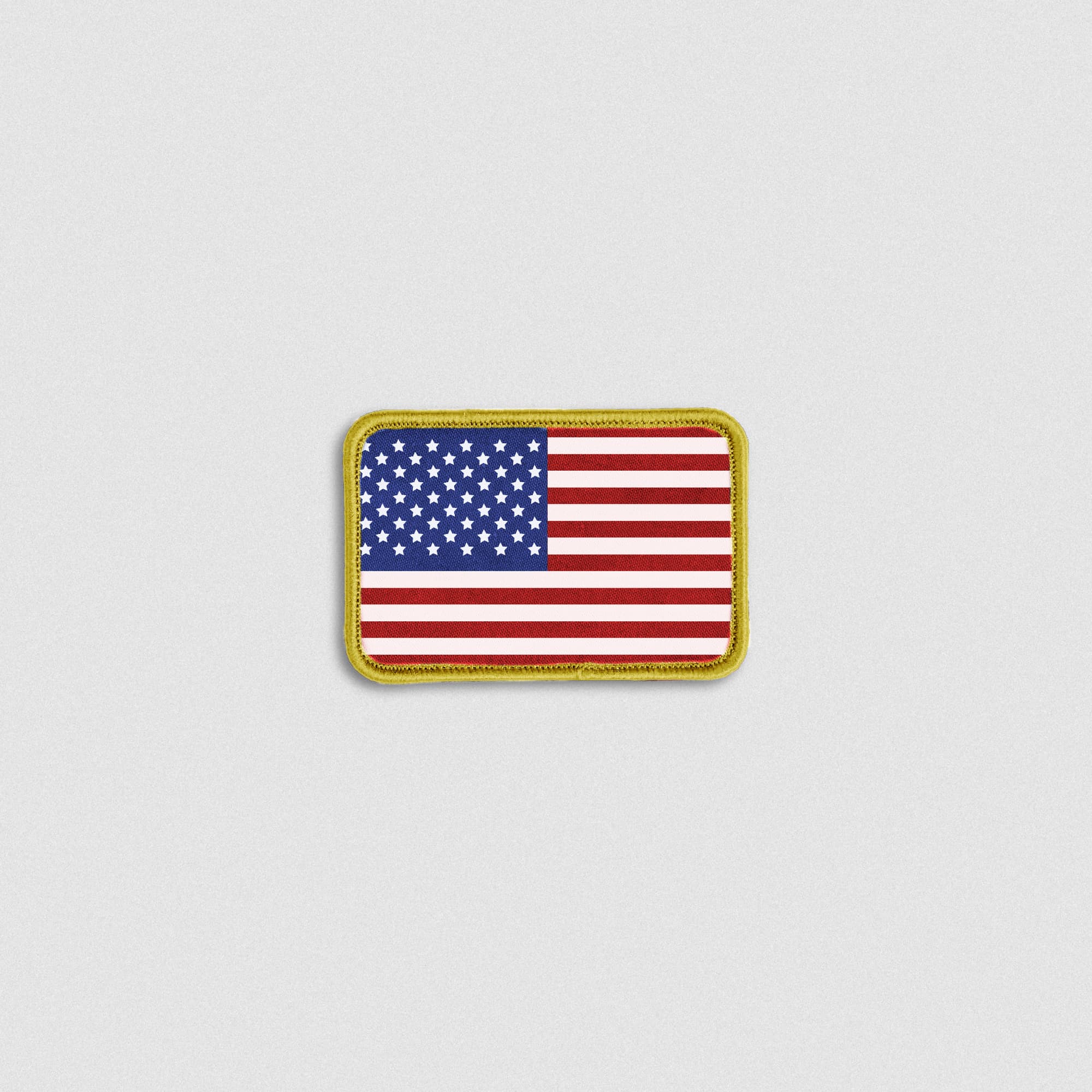Rectangular fabric patch featuring a full-color USA flag with a gold border and hook-and-loop backing.