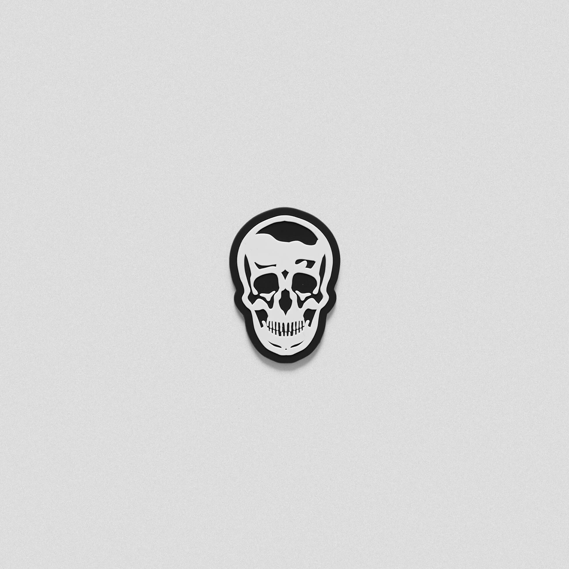 A black white patch in the shape of the Gymreapers skull logo.